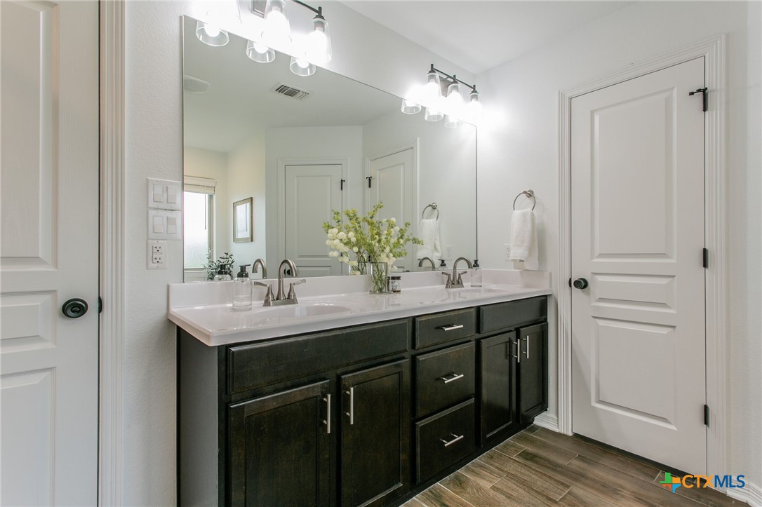 8304 Split Trl Cove Temple, TX 76502 - Photo 12 of 28 a bathroom with a double vanity sink and a mirror