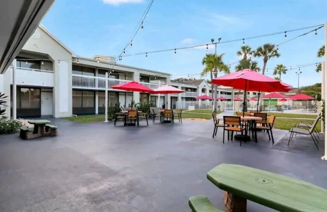 a view of a chairs and tables in patio and a backyard