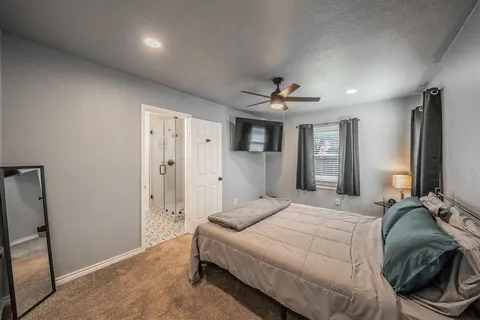a spacious bedroom with a bed and a chandelier