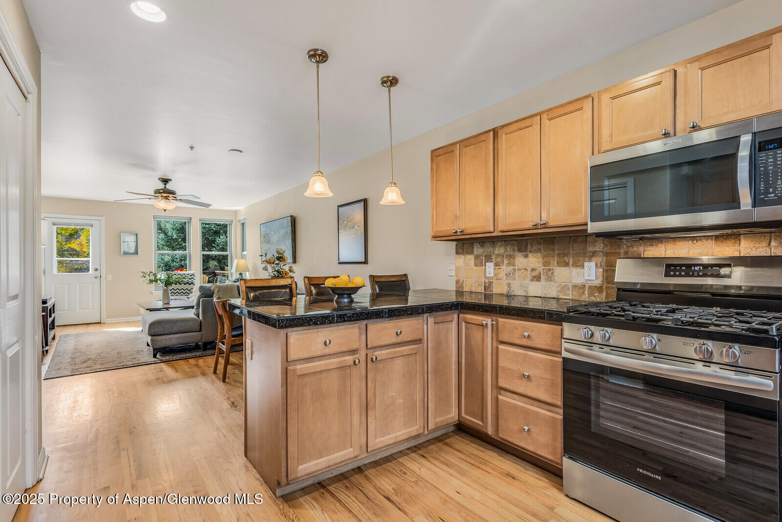 113 Lakeside Court Basalt, CO 81621 - Photo 11 of 39 a kitchen with stainless steel appliances granite countertop a stove top oven a sink dishwasher and white cabinets with wooden floor