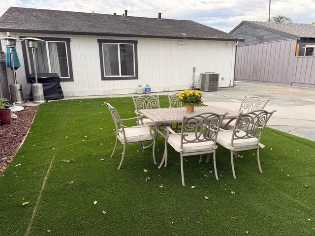 a view of a backyard with table and chairs with wooden fence