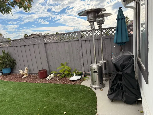 a view of a backyard with furniture and a grill