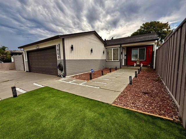a view of house with backyard and furniture