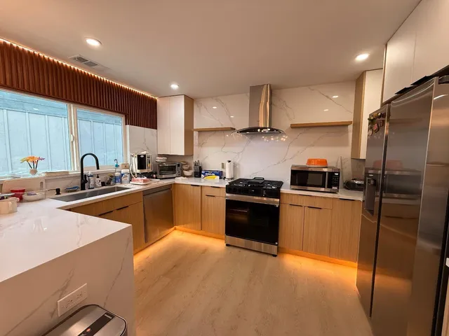 a kitchen with stainless steel appliances a refrigerator sink and stove