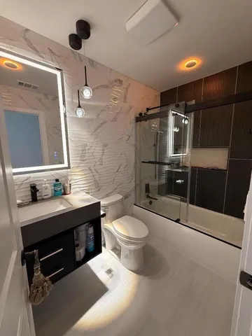 a bathroom with a sink a toilet and shower