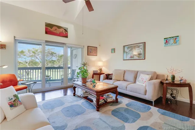 a living room with furniture a window and a ceiling fan