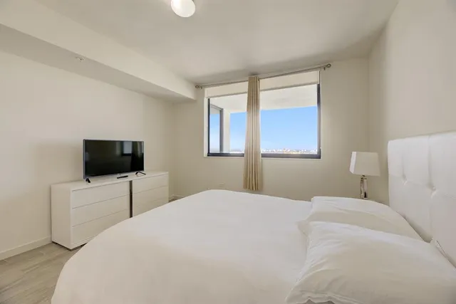 a bedroom with a bed and a flat screen tv