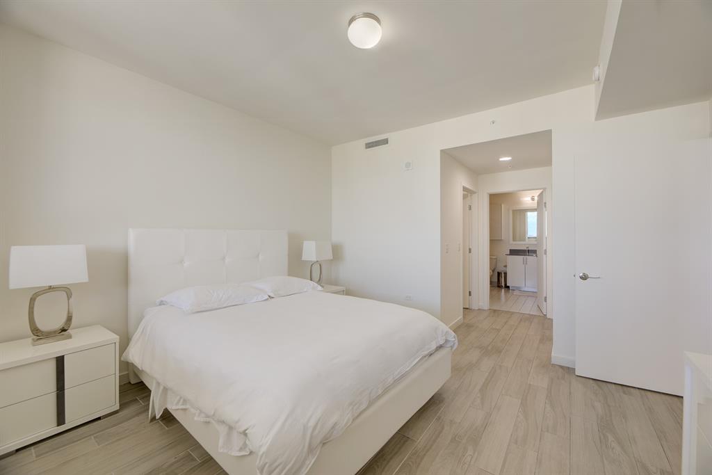 999 Southwest 1st Avenue, Unit 2913 Miami, FL 33130 - Photo 15 of 36 a bedroom with a bed and a lamp