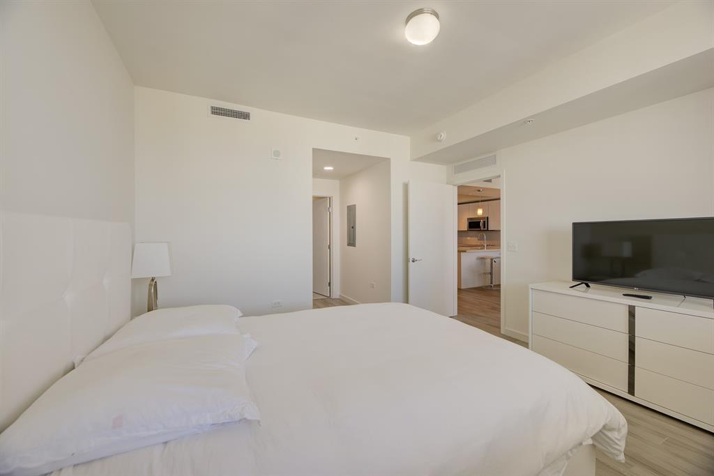 999 Southwest 1st Avenue, Unit 2913 Miami, FL 33130 - Photo 16 of 36 a bedroom with a bed and a flat screen tv