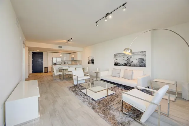 a living room with furniture and view of kitchen