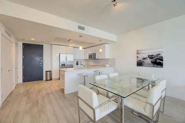 a kitchen with kitchen island a stove a table and chairs in it