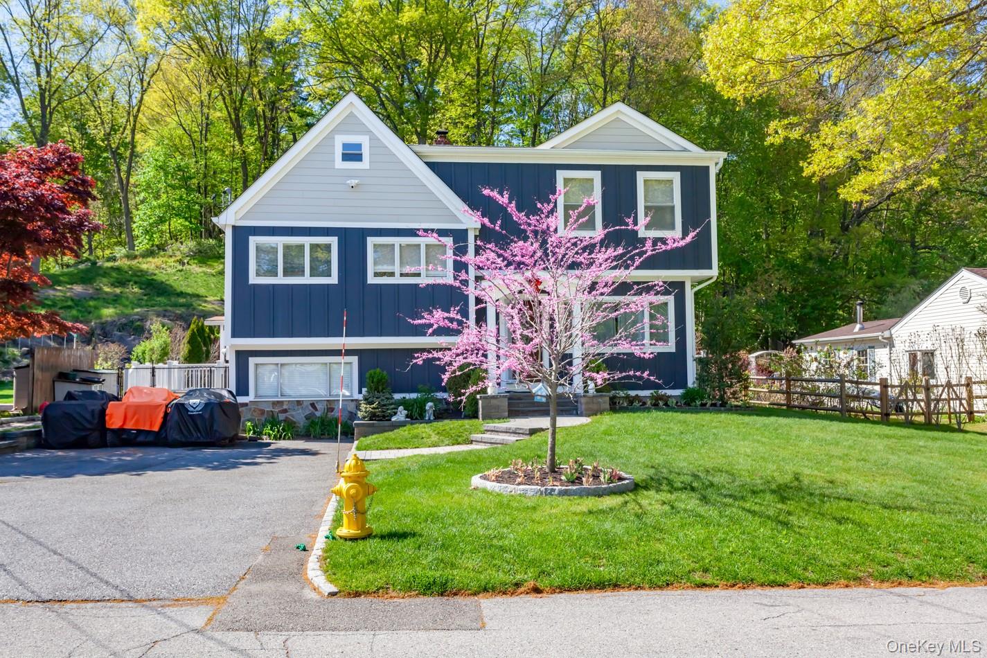 Two-story residence featuring deep blue vertical siding with light gray shingle accents and white trim
