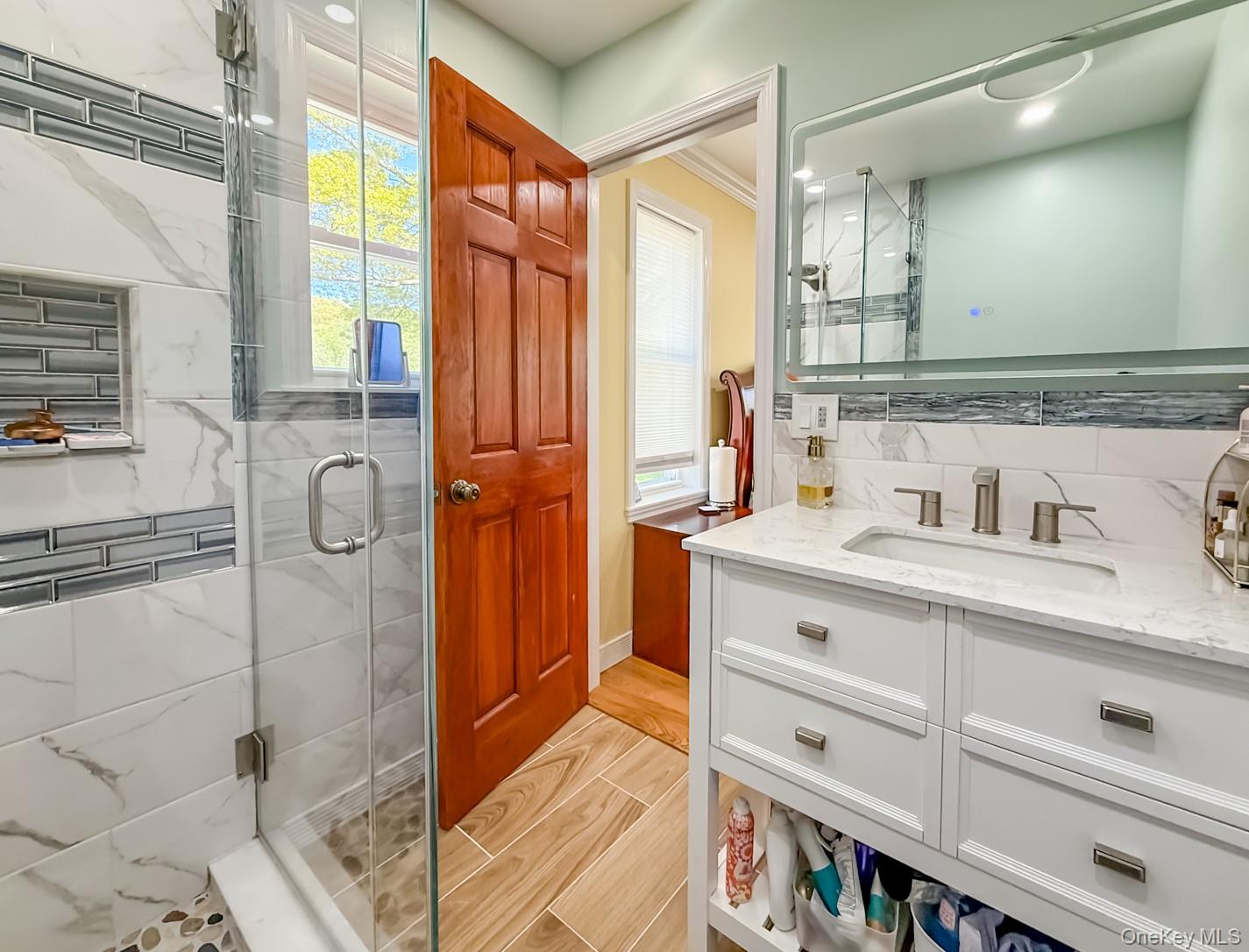 49 Meadow Road Montrose, NY 10548 - Photo 22 of 50 Glass-enclosed shower with white and grey marble-look tile, accenting grey mosaic tile, and a built-in niche