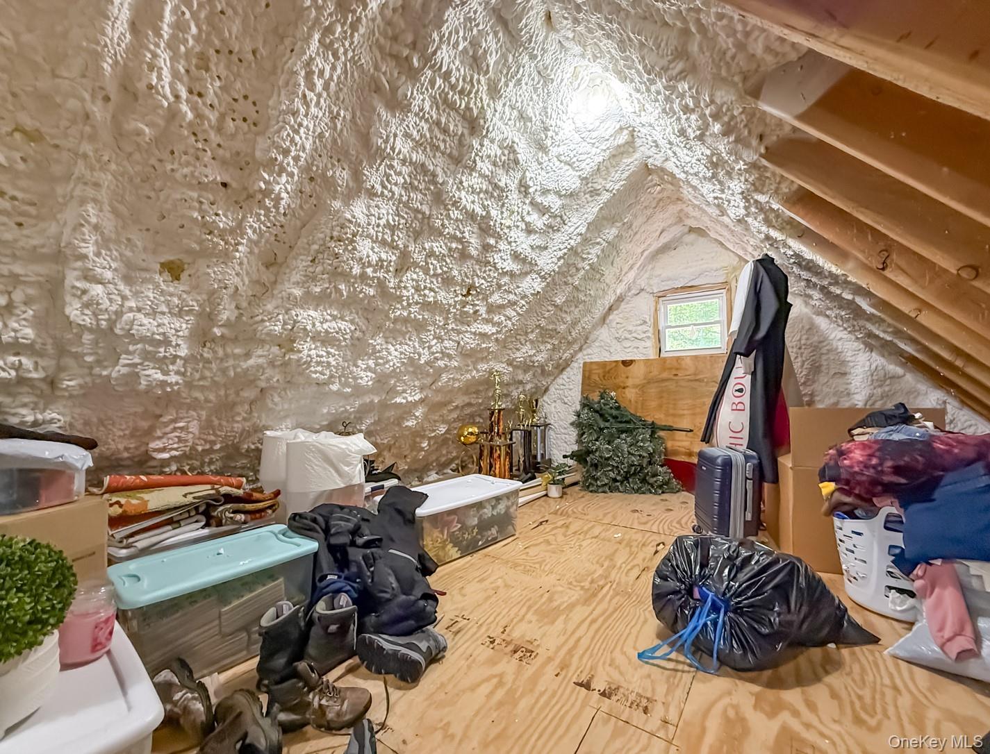 49 Meadow Road Montrose, NY 10548 - Photo 24 of 50 Attic space featuring spray foam insulation, exposed wood rafters, plywood flooring, and a single window