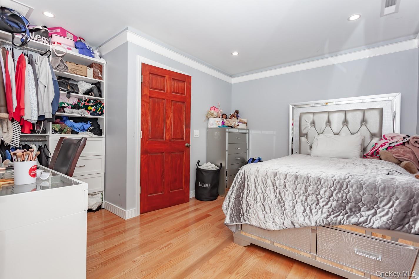 49 Meadow Road Montrose, NY 10548 - Photo 25 of 50 Bedroom featuring wood-finish flooring, recessed lighting, crown molding, a built-in closet organization system, and a six-panel door