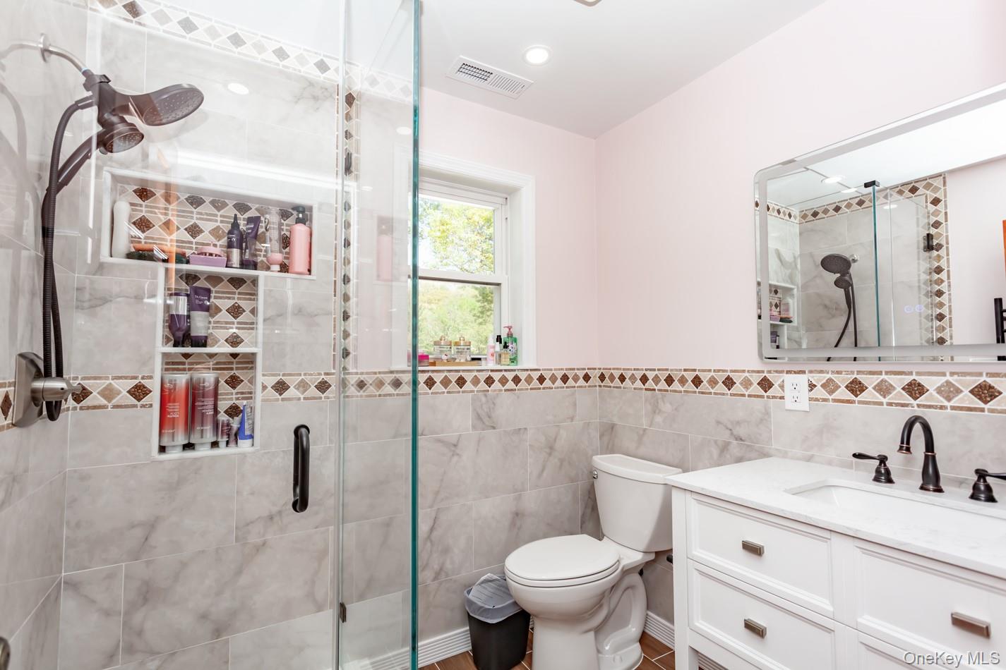49 Meadow Road Montrose, NY 10548 - Photo 27 of 50 Walk-in shower with clear glass enclosure and built-in shelving, featuring a multi-function showerhead