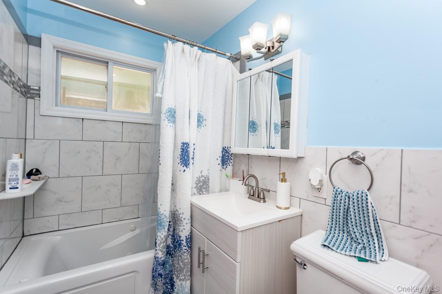 49 Meadow Road Montrose, NY 10548 - Photo 31 of 50 Bathroom featuring a tub/shower combination with tile surround, a built-in window, and a single-sink vanity with under-cabinet storage