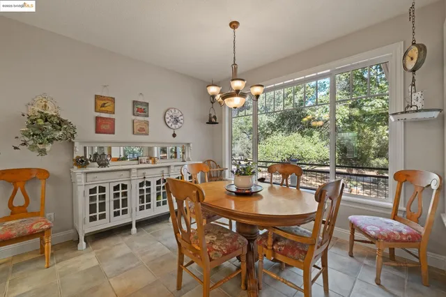 a dining room with furniture a chandelier and window
