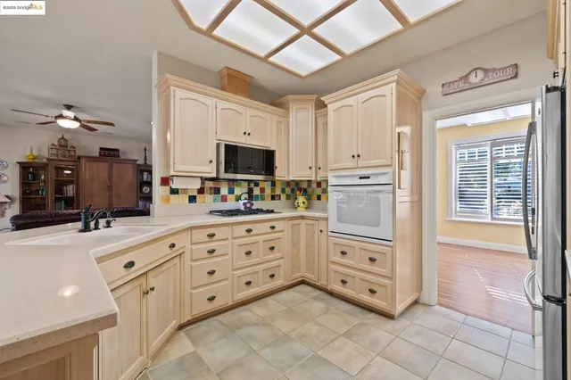 a kitchen with granite countertop white cabinets and stainless steel appliances