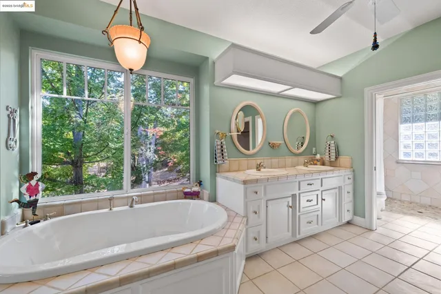 a bathroom with a tub sink and mirror