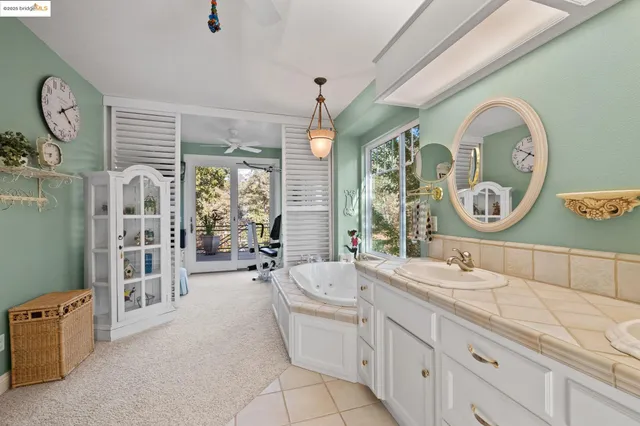 a bathroom with a double vanity sink mirror bathtub and a window