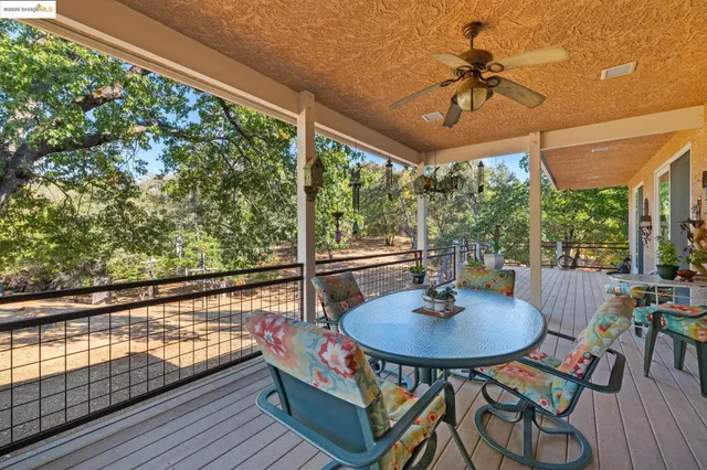 a table and chairs in front of a wooden deck