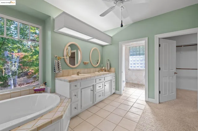a bathroom with a granite countertop sink mirror vanity and bathtub
