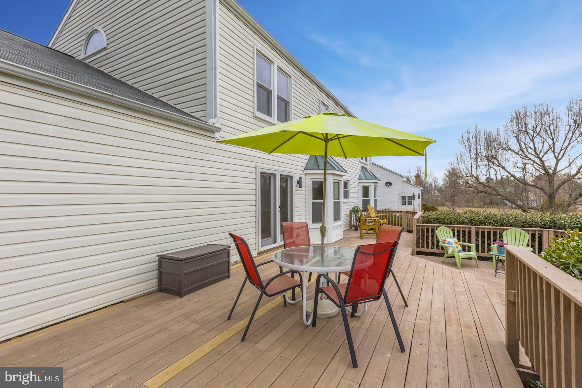 17005 Spates Hill Road Poolesville, MD 20837 - Photo 23 of 25 a view of a roof deck with table and chairs under an umbrella