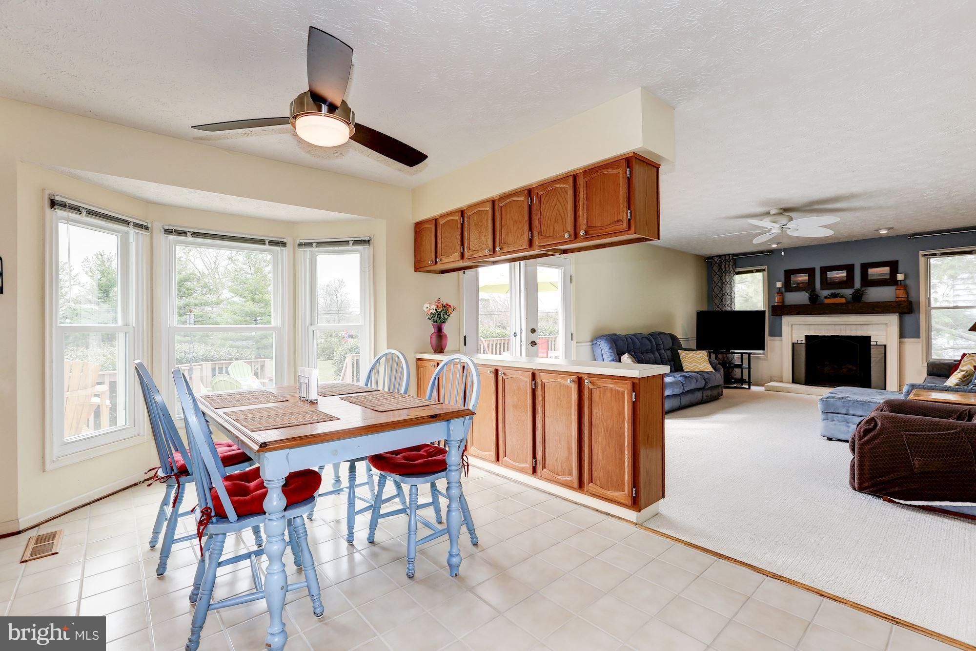 17005 Spates Hill Road Poolesville, MD 20837 - Photo 7 of 25 a dining room with furniture a fireplace and wooden floor