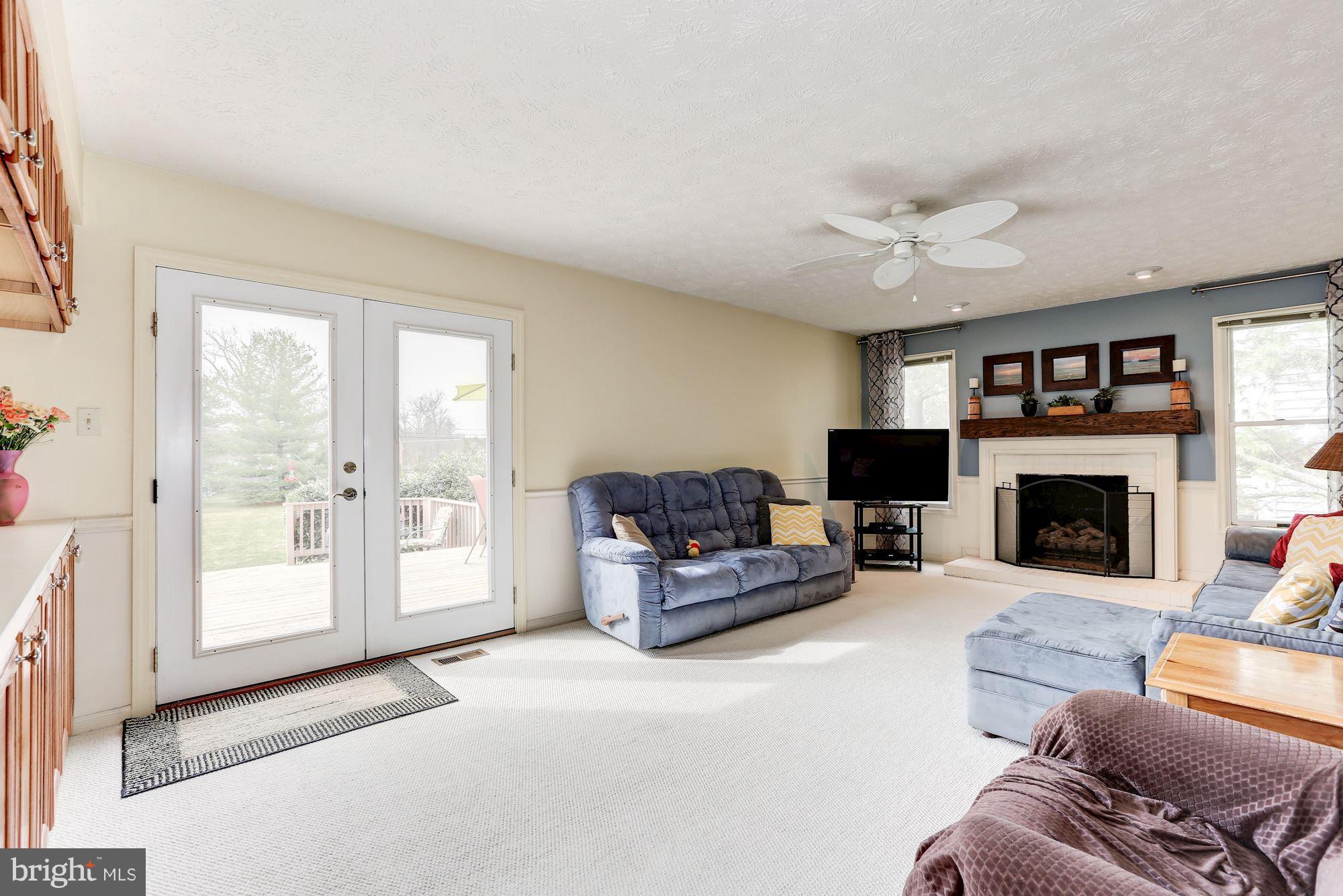 17005 Spates Hill Road Poolesville, MD 20837 - Photo 8 of 25 a living room with furniture a fireplace and a large window