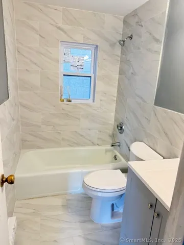 a bathroom with a toilet and a bath tub