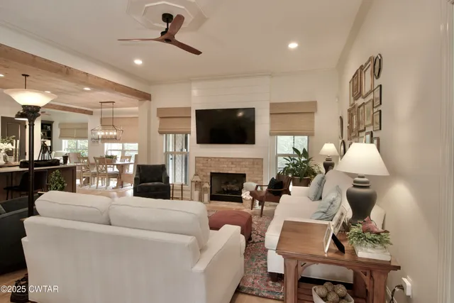 a view of a dining room and livingroom with furniture wooden floor a chandelier