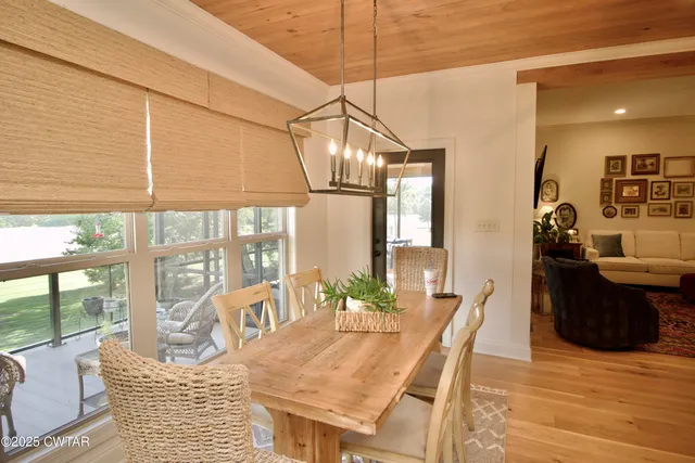 a dining room with furniture a chandelier and wooden floor
