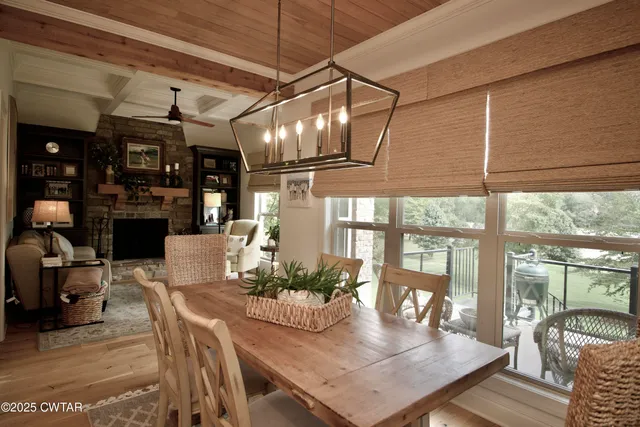 a kitchen with stainless steel appliances kitchen island granite countertop a stove a sink a refrigerator and a dining table with wooden floor