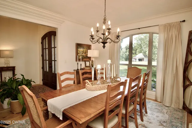 a living room with furniture kitchen view and a chandelier