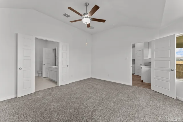 a view of an empty room and a kitchen