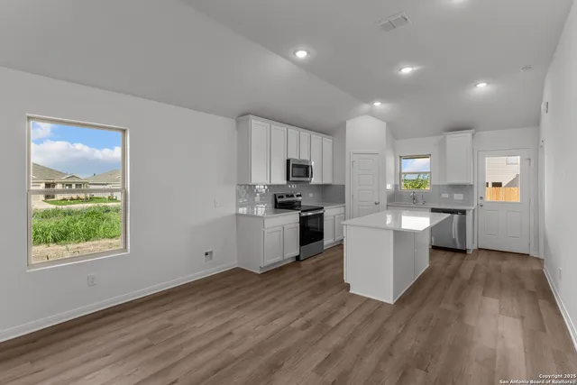 a kitchen with a refrigerator and a stove top oven
