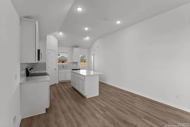 a kitchen with a refrigerator and a stove top oven