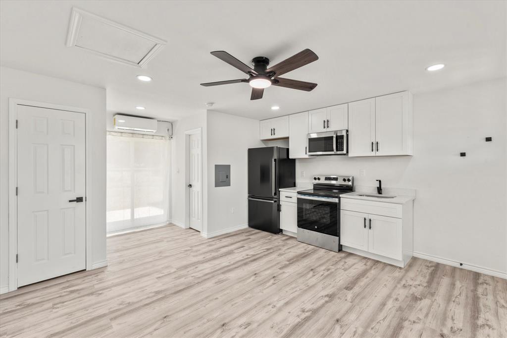 900 South Tool Drive, Unit 5 Tool, TX 75143 - Photo 4 of 7 Kitchen featuring white cabinetry, appliances with stainless steel finishes, light wood-style floors, a ceiling fan, and recessed lighting
