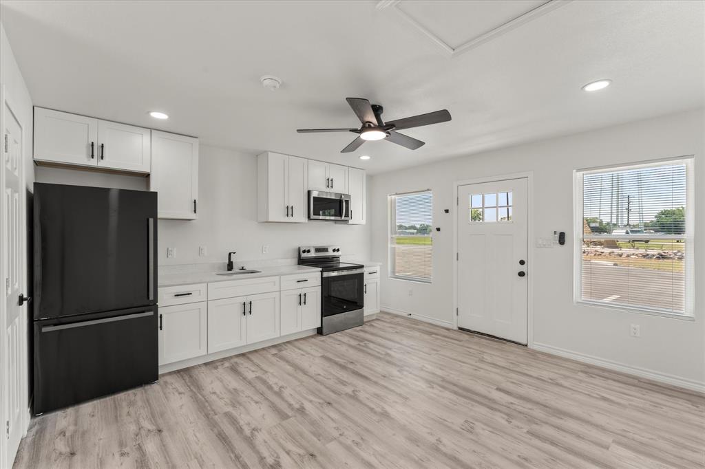 900 South Tool Drive, Unit 5 Tool, TX 75143 - Photo 5 of 7 Kitchen featuring appliances with stainless steel finishes, white cabinets, light countertops, light wood-style flooring, and recessed lighting