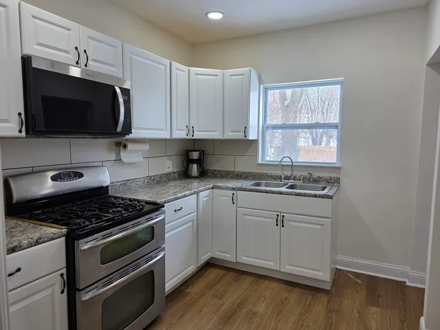 a kitchen with granite countertop a stove and a microwave