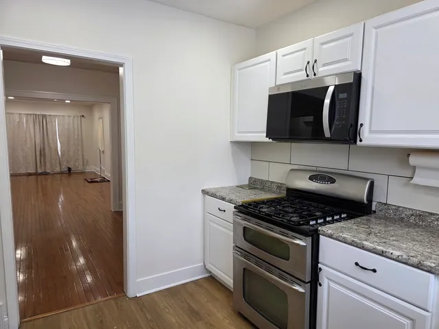 a kitchen with stainless steel appliances granite countertop a stove and a microwave