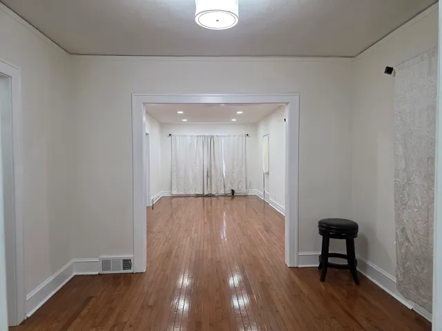 a view of a livingroom with wooden floor and bench