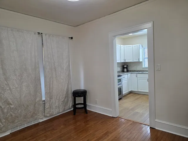 a view of kitchen with wooden floor electronic appliances and chair