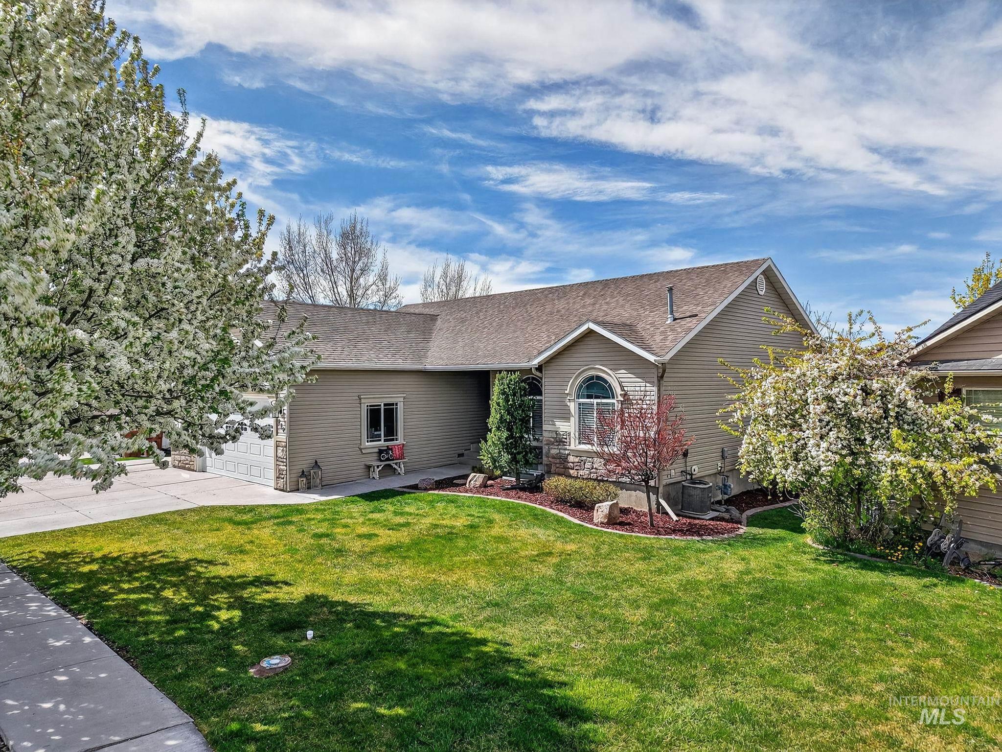 Ranch-style house with a front yard, a garage, and a shingled roof