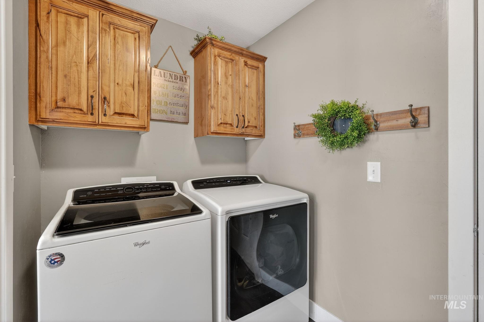 880 Redman Street Chubbuck, ID 83202 - Photo 12 of 39 Laundry room featuring washing machine and clothes dryer and cabinet space