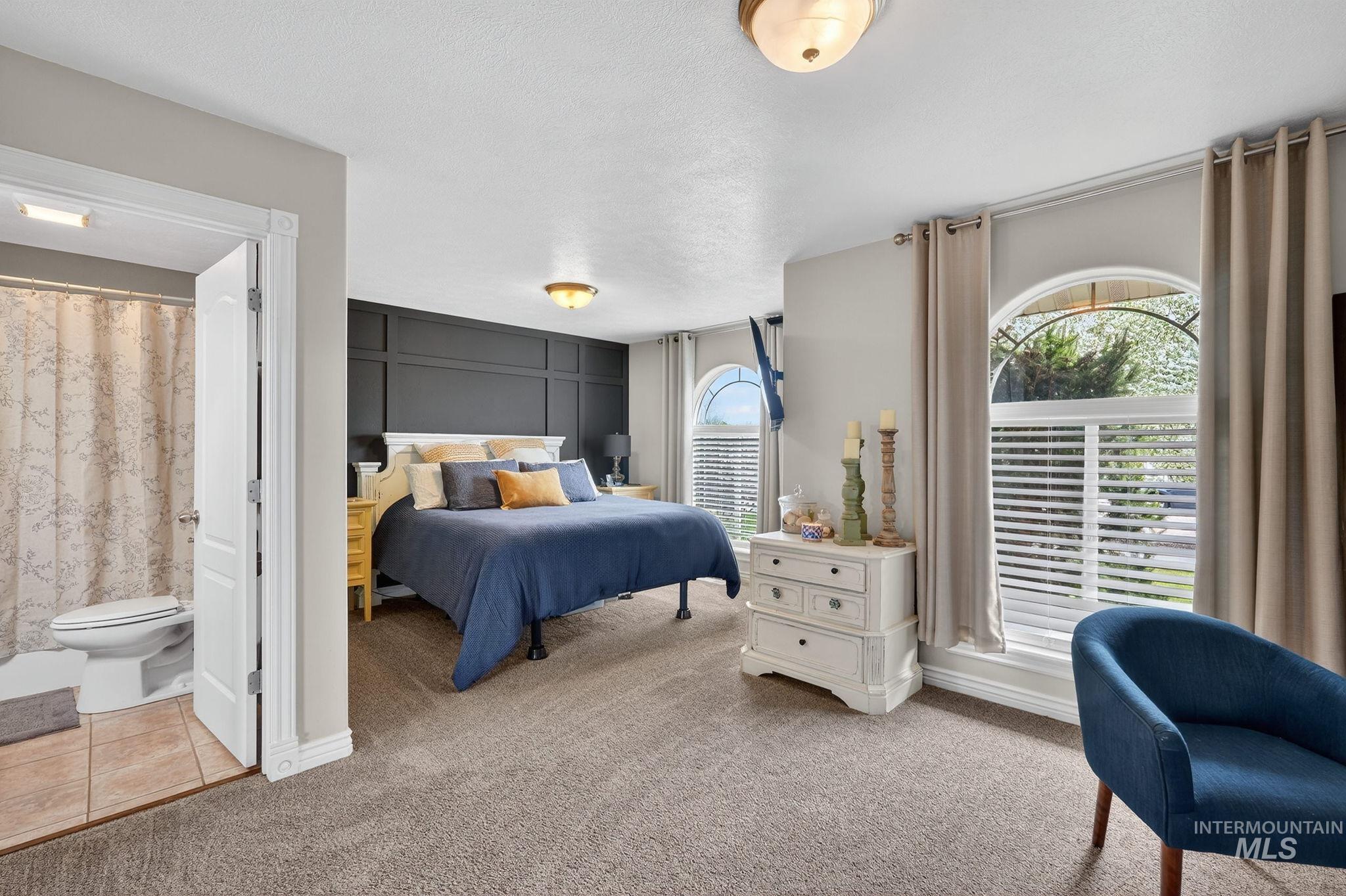 880 Redman Street Chubbuck, ID 83202 - Photo 13 of 39 Bedroom with light colored carpet, multiple windows, and light tile patterned flooring