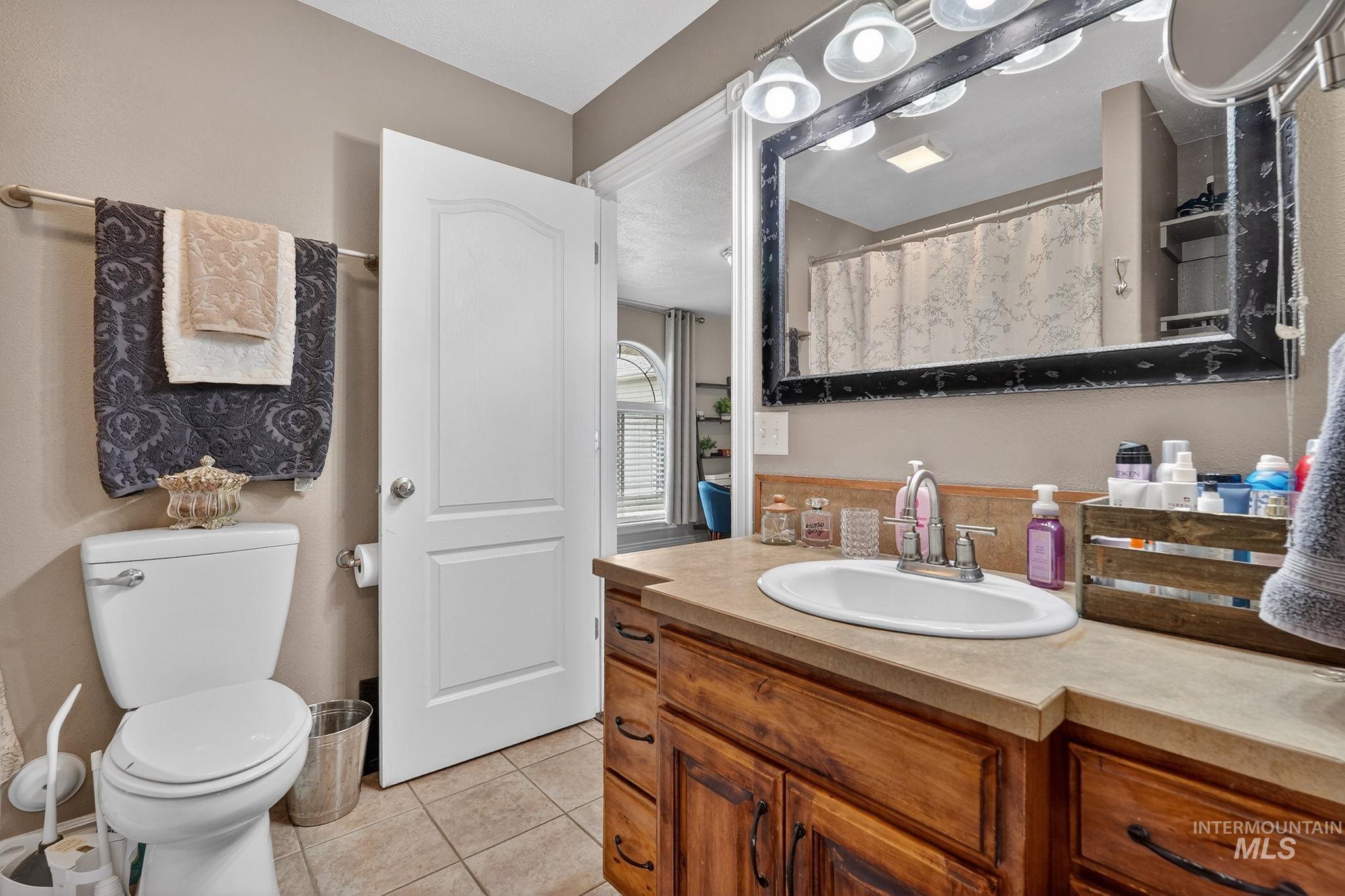 880 Redman Street Chubbuck, ID 83202 - Photo 17 of 39 Full bathroom featuring light tile patterned floors, vanity, and curtained shower