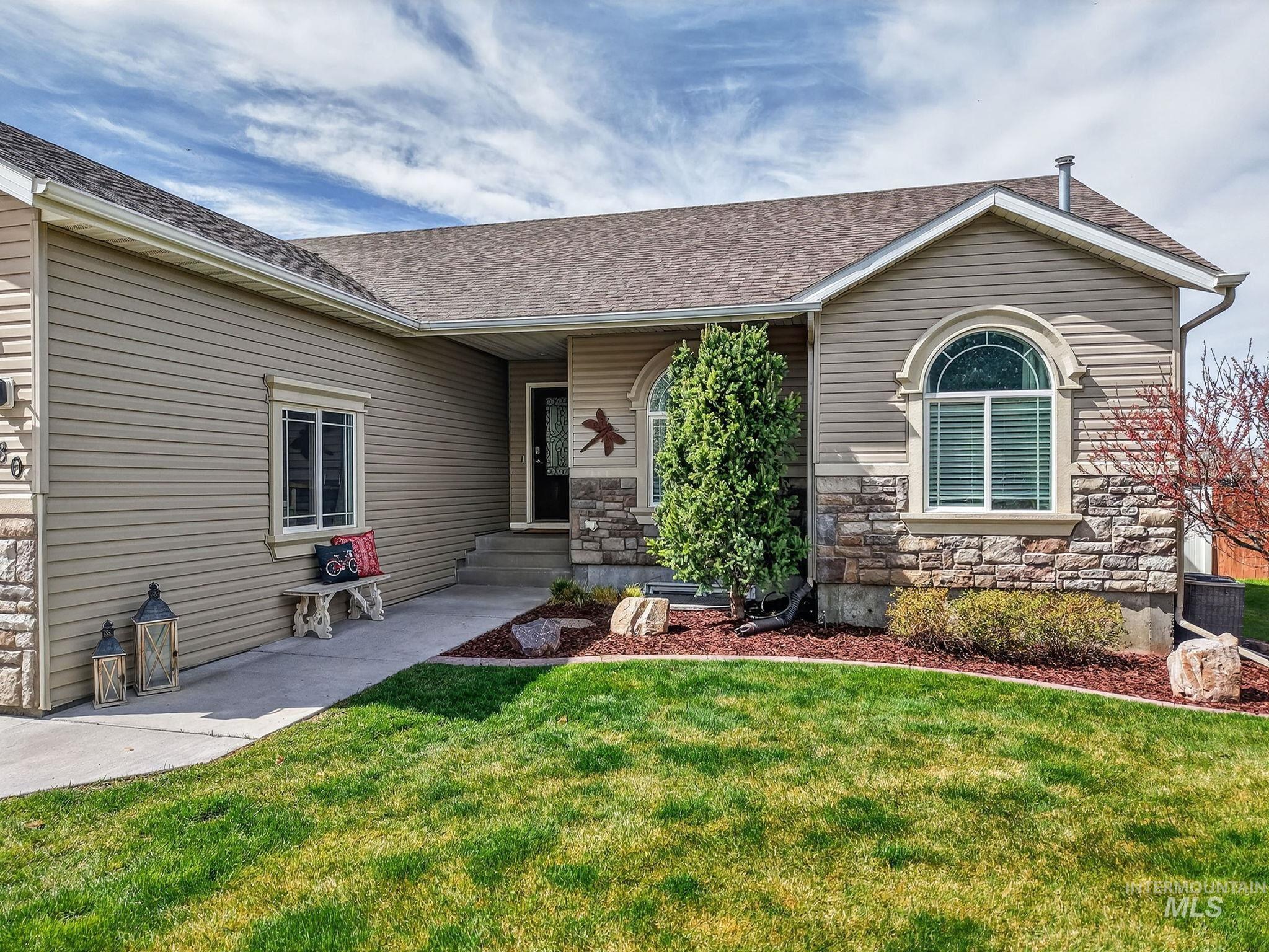 880 Redman Street Chubbuck, ID 83202 - Photo 2 of 39 View of front of property featuring a front yard, stone siding, and a shingled roof