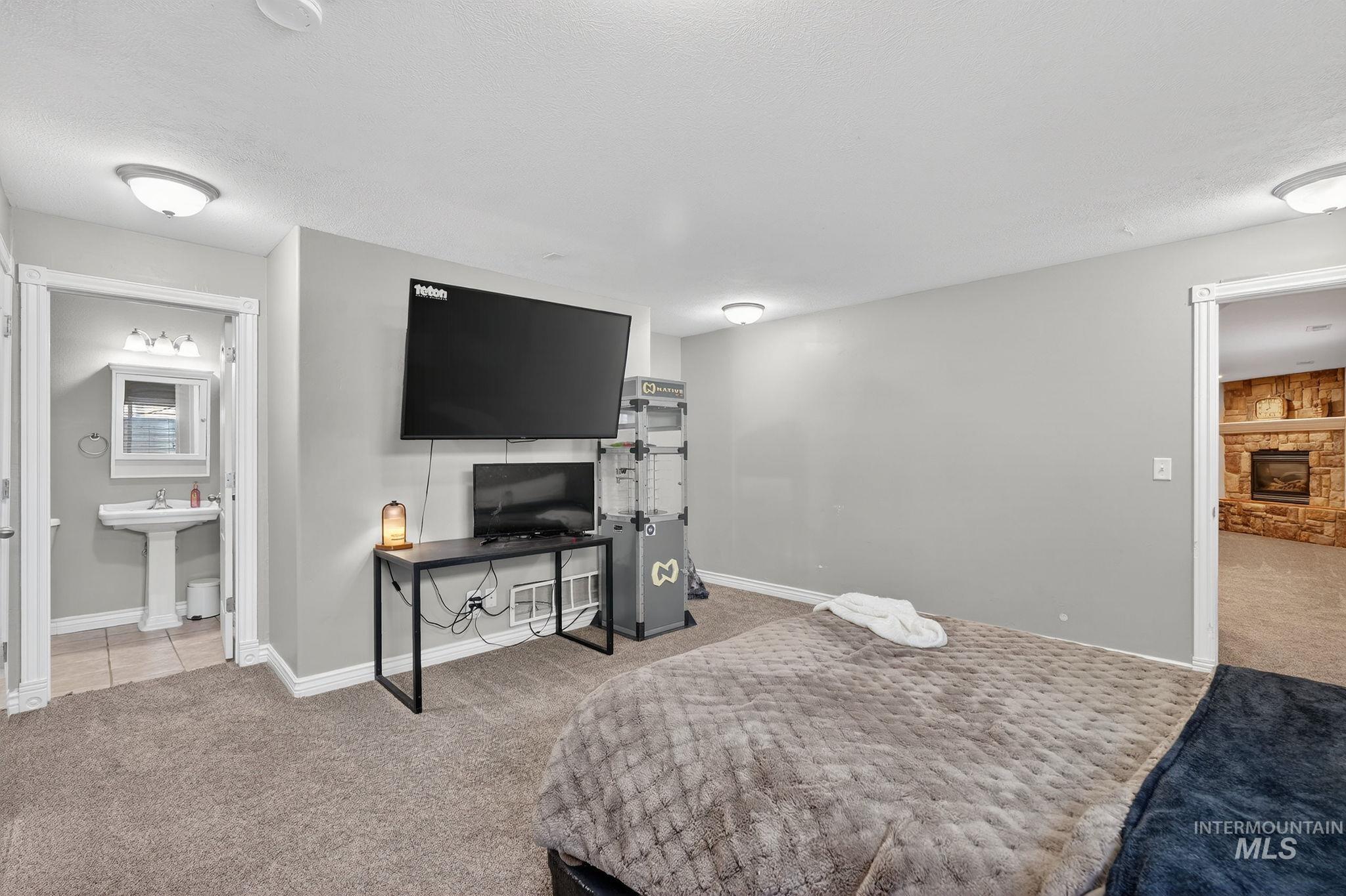 880 Redman Street Chubbuck, ID 83202 - Photo 25 of 39 Bedroom with light colored carpet and a fireplace